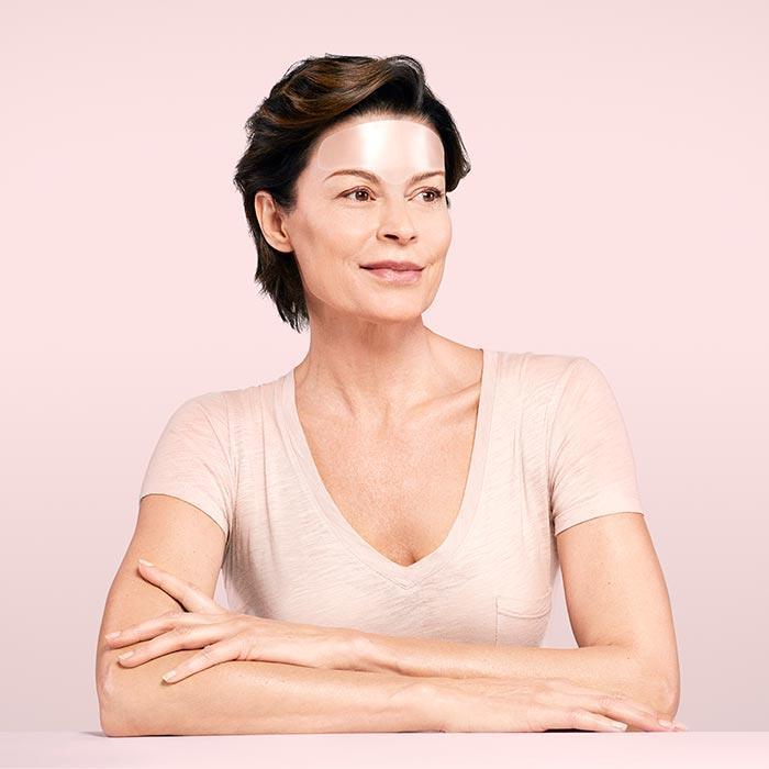 Model wearing anti wrinkle patches on her forehead